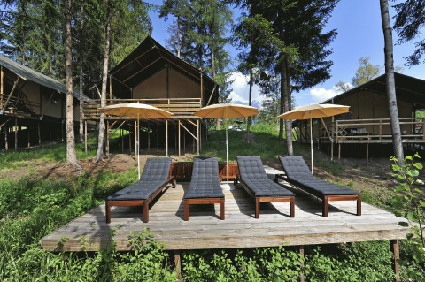 Glamping au Nature Resort Natterer See - Safarilodges Tirol, avec tentes safari, chaises longues et parasols.