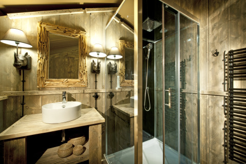 Bathroom of a glamping safari lodge at Nature Resort Natterer See, Tirol, with rustic wood decor and a shower.