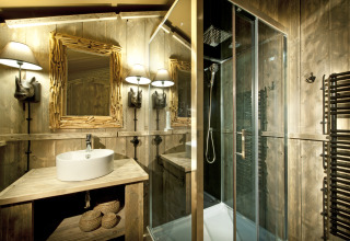Bagno di una glamping safarilodge presso il Nature Resort Natterer See, Tirolo, con arredo rustico in legno.