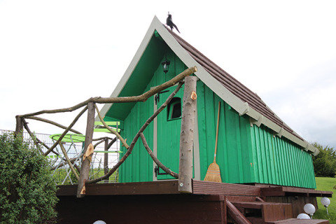 Green glamping cabin with rustic wooden porch and broom, Camping Naumburg - Glamping Hessen countryside stay
