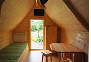Vista interior del alojamiento glamping en Camping Naumburg - Glamping Hessen, con decoración de madera y comodidades.