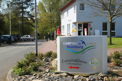 Indgang til Camping Naumburg i Hessen med et skilt, der viser campingpladsens navn og reception.