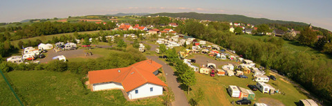 Aerial view of Camping Naumburg - Glamping Hessen with caravans, tents, and greenery in the countryside.