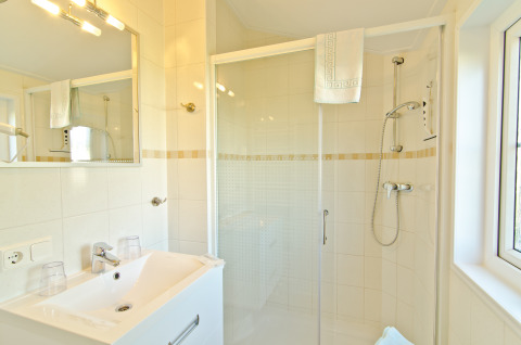 Lichte, moderne badkamer in glampingaccommodatie bij Campingpark Kerstgenshof, met douche en handdoeken.