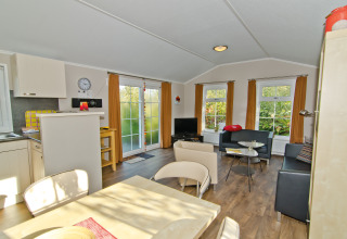 Interior view of Landhuis Chalet at Campingpark Kerstgenshof, featuring modern furniture and large windows.