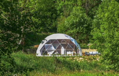 Cupola geodetica per glamping al Domaine la Chabanne - Domes Auvergne-Rhône-Alpes immersa nel verde.
