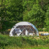Geodesic dome glamping tent at Domaine la Chabanne - Domes Auvergne-Rhône-Alpes surrounded by lush trees.