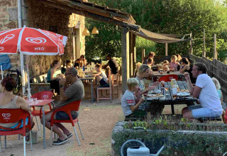 Gäste essen im Freien bei Domaine la Chabanne - Domes Auvergne-Rhône-Alpes an einem sonnigen Tag.