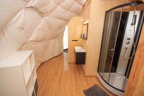 Vista interior de alojamiento glamping con baño moderno en Domaine la Chabanne - Domes Auvergne-Rhône-Alpes.