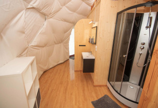 Vue intérieure d'un hébergement glamping avec salle de bain moderne au Domaine la Chabanne - Domes Auvergne-Rhône-Alpes.