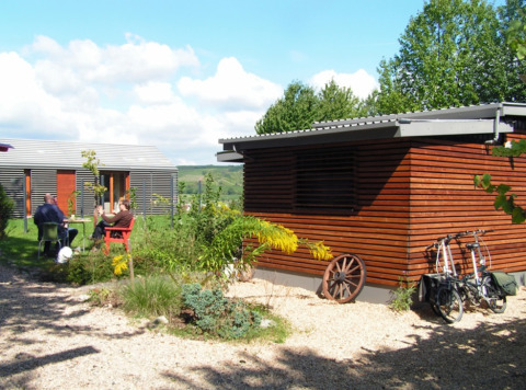 Moderne glampingindkvartering på Campingpark Lindelgrund - Chalets Rheinland-Pfalz med gæster udendørs.