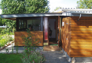 Modern glamping verblijf op Campingpark Lindelgrund - Chalets Rheinland-Pfalz met houten gevel en tuin.