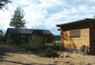 Moderne houten chalets bij Campingpark Lindelgrund in Rheinland-Pfalz, te midden van groene natuur.