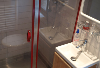 Badkamer met douche, wastafel en spiegel in een chalet op Campingpark Lindelgrund, Rheinland-Pfalz.