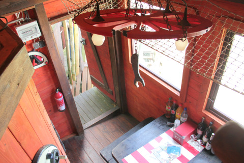 Interieur van glampingverblijf Erlebnisbahn Ratzeburg - Treinwagonhotel met houten wanden en tafel.