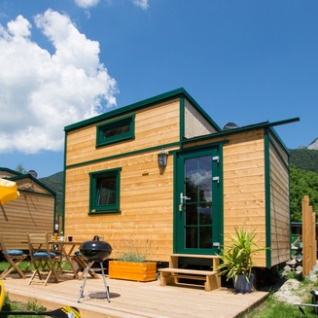 Wooden tiny house at Seecamping Appesbach, Austria, with deck and grill, ideal for lakeside glamping stays.