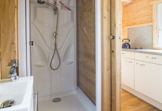 Moderne brusekabine og køkken i træinteriør på Seecamping Appesbach - Tiny House i Østrig.