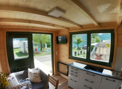 Vista interna di una Tiny House a Seecamping Appesbach con cucina moderna e vista sull’area campeggio.