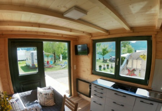 Vista interior de una Tiny House en Seecamping Appesbach, con cocina moderna y vista al área de camping.