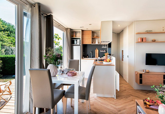 Lichte, moderne glampingaccommodatie met open keuken en eetruimte bij Camping Wallersee - Stacaravans Salzburg.