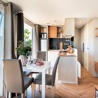 Sistemazione glamping moderna e luminosa con cucina a vista e zona pranzo presso Camping Wallersee - Stacaravans Salzburg.