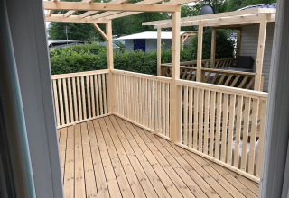 Houten terras met balustrade en pergola bij Camping Wallersee - Stacaravans Salzburg glamping accommodatie.
