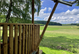 Udsigt fra glamping-indkvartering på Camping Azur Sonnenbühl - Nature Lodge Baden-Württemberg over grønne marker.
