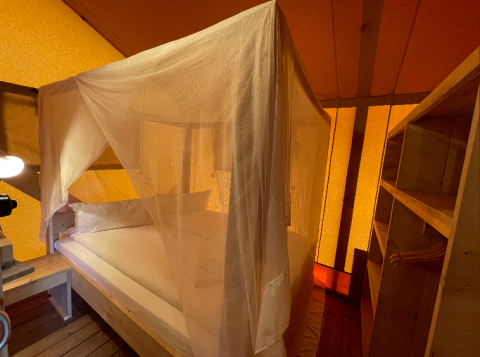 Glamping accommodatie bij Camping Azur Sonnenbühl - Nature Lodge Baden-Württemberg met hemelbed en houten interieur.