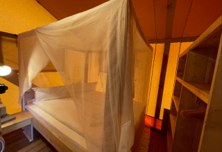 Glamping accommodation at Camping Azur Sonnenbühl - Nature Lodge Baden-Württemberg with canopy and wood interior.