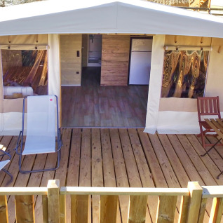 Alojamiento glamping con terraza de madera, tumbonas y mesa en Vacanze col Cuore, Lago de Garda.