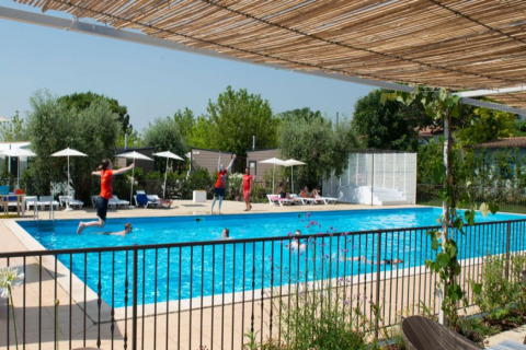 Zwembad bij Vacanze col Cuore: Vacanze Glamping Boutique - Lodgetenten Gardameer, gasten ontspannen.