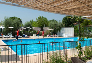 Piscina en Vacanze col Cuore: Vacanze Glamping Boutique - Lodgetenten Gardameer con huéspedes disfrutando.