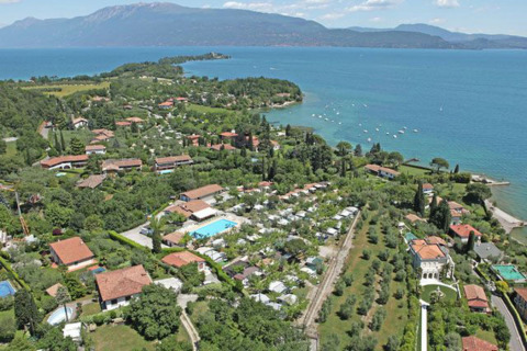 Vista aérea de Vacanze col Cuore: Vacanze Glamping Boutique con tiendas lodge junto al lago de Garda.