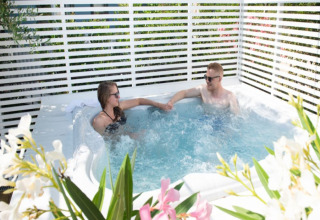 Deux personnes se détendent dans un jacuzzi chez Vacanze col Cuore : Vacanze Glamping Boutique près du lac de Garde.