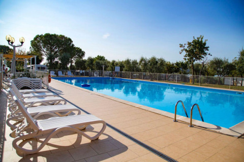 Piscine extérieure avec transats et arbres à Vacanze col Cuore : Vacanze Glamping Boutique au Lac de Garde.