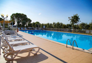 Piscina all'aperto con lettini prendisole e alberi presso Vacanze col Cuore: Vacanze Glamping Boutique Lago di Garda.
