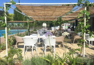 Außenterrasse bei Vacanze Glamping Boutique Gardasee mit modernen Möbeln, Pergola und Blick auf den Pool.
