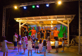 Bambini partecipano all’intrattenimento serale sul palco durante il glamping Vacanze col Cuore al Lago di Garda.