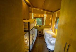 Indretning af glamping-telt med køjesenge og enkeltsenge hos Vacanze col Cuore ved Gardasøen.