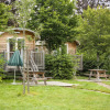 Wooden cabins and picnic benches surrounded by greenery at Huttopia Etang de Fouché Glamping Bourgogne, France.