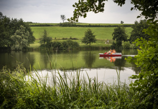 Gezin geniet van een waterfietstocht op het meer bij Huttopia Etang de Fouché Glamping Bourgogne.