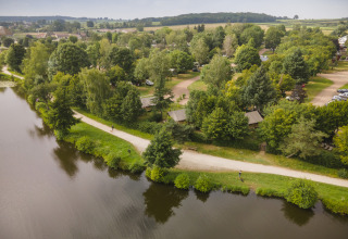 Luchtfoto van Huttopia Etang de Fouché - Glamping Bourgogne, met tenten tussen bomen bij het water.