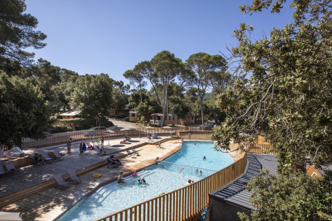 Buitenzwembad met ligstoelen en bomen bij glamping Huttopia Forêt de Janas aan de Côte d’Azur, Frankrijk.