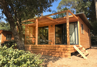 Alloggio glamping in legno a Huttopia Forêt de Janas, Côte d’Azur, immerso tra alberi e natura.