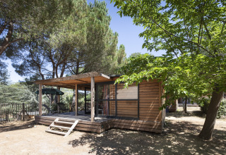Cabane en bois sous les arbres à Huttopia Forêt de Janas - Glamping Côte d’Azur, hébergement en plein air.