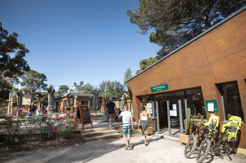 Glamping Huttopia Forêt de Janas sulla Costa Azzurra con ospiti, biciclette e area esterna soleggiata.