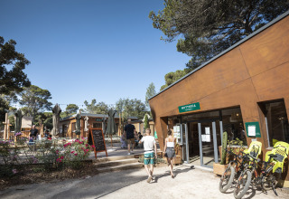 Glamping Huttopia Forêt de Janas sulla Costa Azzurra con ospiti, biciclette e area esterna soleggiata.