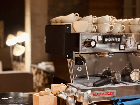 Macchina per espresso con tazze impilate a Basecamps - Cabins Girona, alloggio campeggio e glamping.