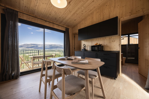 Moderne Basecamps - Cabins Girona glampingindkvartering med træinteriør og udsigt over bjergene.