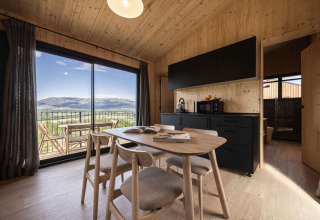 Moderne Basecamps - Cabins Girona glampingindkvartering med træinteriør og udsigt over bjergene.